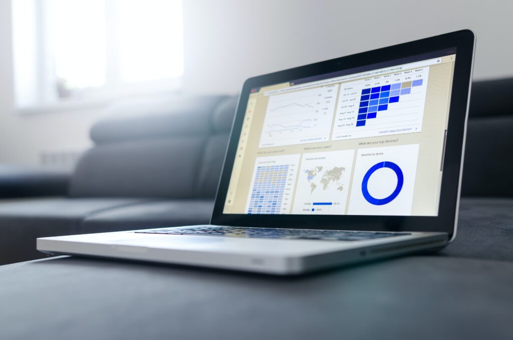 Black and grey laptop showing graphs and charts on screen.